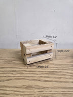 A small rustic wooden crate-style container made from pallet wood shown on a wood surface against a light wall, with overlaid dimension labels indicating width 2.5 inches, height 2.